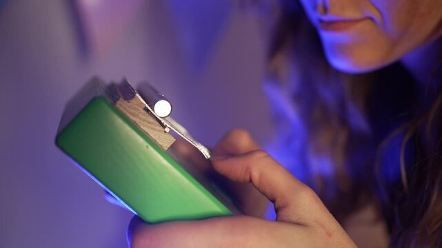 Young woman musician playing a green kalimba, a modern version of the african mbira, also known as a thumb piano, creating soothing melodies