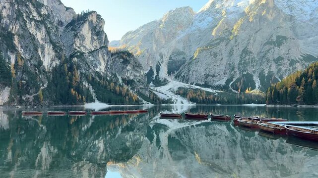 Explore Lago di Bries with serene waters, stunning mountains, and peaceful boats at dawn