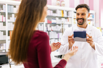 Young woman getting advice from pharmacist about vitamins