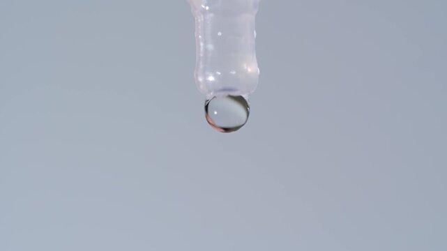 Close-up of a disposable eye drop vial administering a clear liquid solution into a person's open eye for hydration or medical treatment.