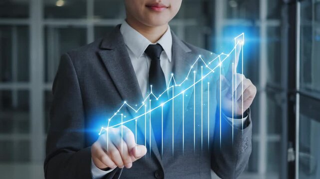 Business professional interacting with futuristic glowing financial graph displaying upward trend and growth analytics on digital interface with subtle bokeh