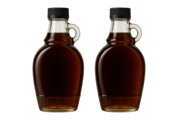 Two glass jugs of golden maple syrup, ready for sweetening breakfast, pancakes, waffles, or desserts, transparent background