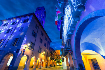 Evening view of the picturesque Italian town of Alba, illuminated with festive Christmas lights.