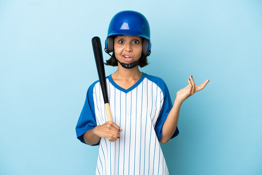 Baseball mixed race player woman with helmet and bat isolated on blue background with shocked facial expression