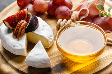 Appetizer board with meat, cheese, grapes, nuts and fresh figs.