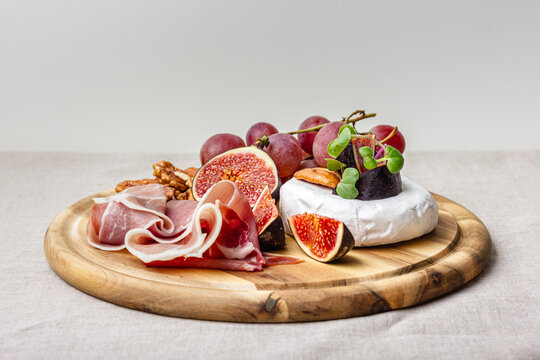 Appetizer board with meat, cheese, grapes, nuts and fresh figs. - Powered by Adobe