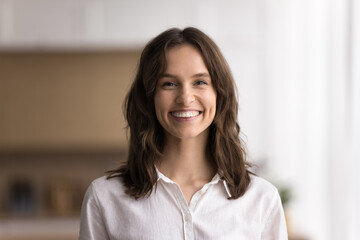 Headshot beautiful young woman looking at camera with white smile