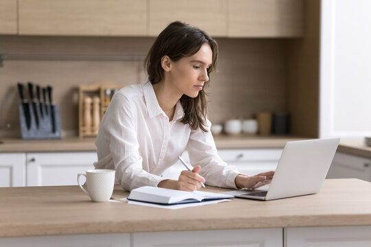 Young woman remote student watch webinar via notebook take notes