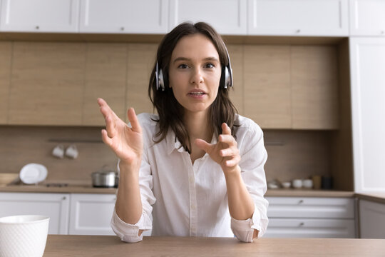 Webcam view young female wearing earphones communicating by video call