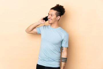 Caucasian man over isolated background keeping a conversation with the mobile phone