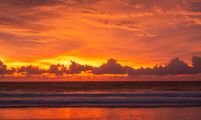 Stunning orange sunset sky over calm ocean waves with golden light reflections. Ideal for travel themes, tropical landscapes, peaceful backgrounds, meditation, or beach resort branding.