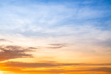 Obraz premium Sunset or sunrise sky with a vibrant gradient of orange, gold, and soft blue. Clear atmosphere with wispy clouds. Peaceful, natural light background. hope, freedom, new day and inspirational Concepts