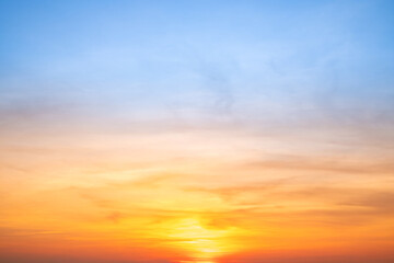 Sunset or sunrise sky with a vibrant gradient of orange, gold, and soft blue. Clear atmosphere with wispy clouds. Peaceful, natural light background. hope, freedom, new day and inspirational Concepts
