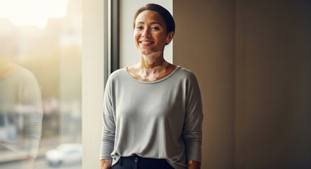 Confident woman standing by window in modern urban setting