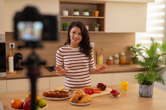 Woman food blogger vlogging about healthy cooking in kitchen - Powered by Adobe