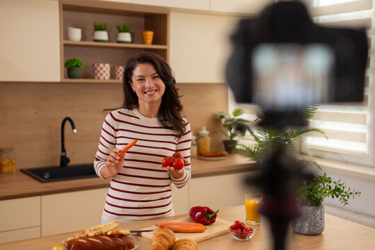 Woman food vlogger recording healthy cooking video in kitchen - Powered by Adobe