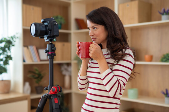 Woman creating online video content relaxing with coffee