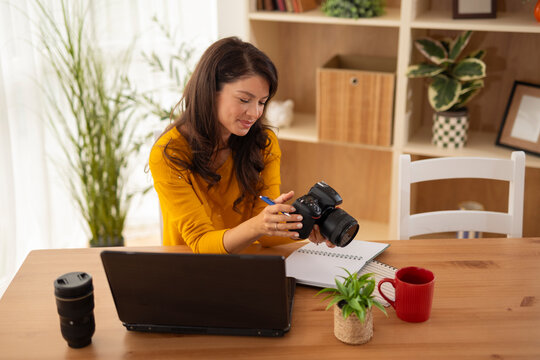 Woman learning photography online holding a camera