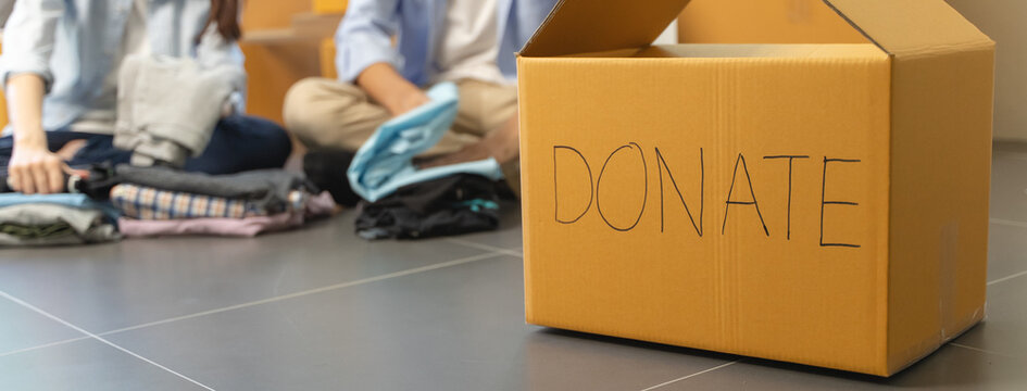 Group of people preparing clothes in donation box preparing to give to another people - Powered by Adobe