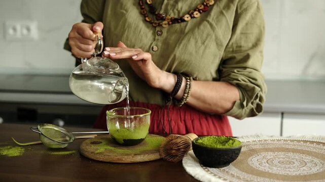 Close-Up Of A Woman Adding Water To Matcha Tea Preparation