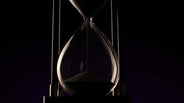 sand moving silently through a glass timer, symbolizing the eternal rhythm of passing time