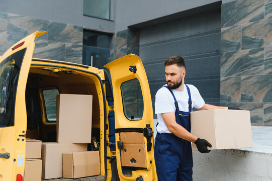 Delivery man unloading cardboard boxes from delivery van