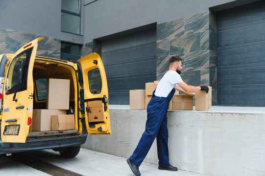 Delivery driver unloading cardboard boxes from yellow van - Powered by Adobe