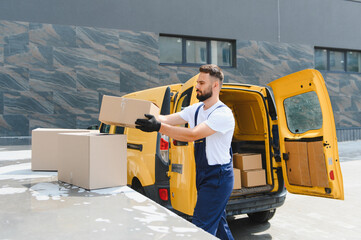 Courier loading cardboard boxes into delivery van