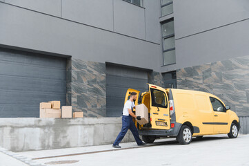 Deliveryman unloading cardboard boxes from yellow van