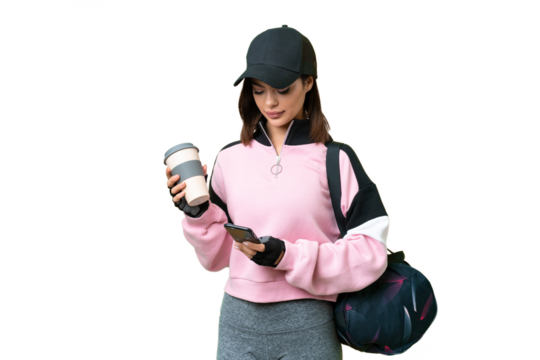 Young sport woman with sport bag over isolated chroma key background holding coffee to take away and a mobile