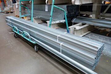 Galvanized steel tubes on a cart in a home improvement store warehouse during the afternoon for...