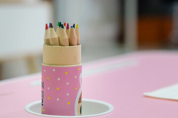 A set of colored pencils in the case on the table