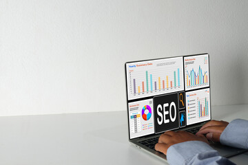 SEO,Digital marketing,Business technology concept.,Businessman analyzing Search Engine Optimization data on a laptop dashboard with charts and graphs on white background with copyspace.