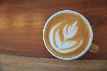 Top view of latte art coffee on wooden table for drinking in morning