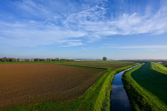 High-Angle View of a Dutch Polder Landscape with Tilled Fields and a Straight Canal under a Clear Blue Sky in the Biesbosch, Netherlands