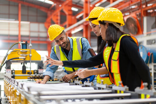 engineer worker woman man in safety vest and helmet check material with blueprint, people working in industrial manufacturing factory planning to inspect repairing equipment in production warehouse