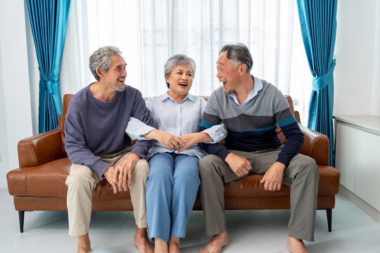 asian family group of senior man woman smiling sitting together in living room. home caregiver nurse visit retirement patient for health check up recovery process medical service - Powered by Adobe