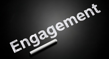 The word engagement written in chalk on a black chalkboard with a piece of chalk