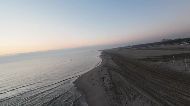 Drone flies over the beach at dawn