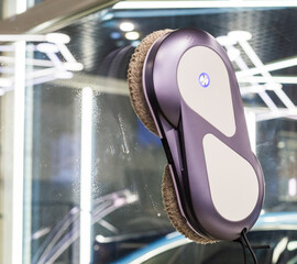 Automated window cleaning robot on a large glass pane in a bright modern apartment. Automatic window cleaning robot washing glass in high-rise building, providing convenience, efficiency for home. 