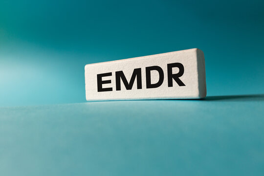 EMDR symbol. Eye Movement Desensitization and Reprocessing. Medical concept. Modern forms of therapy. Text EMDR written on a wooden element. Business concept.blue background. Close up. Copy space