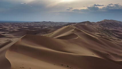 Aerial view of sand dunes in desert at sunset