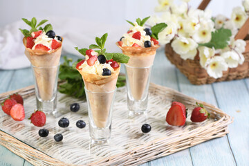 crepes with whipped cream filling, strawberries, blueberries, almond petals, garnished with mint
 
