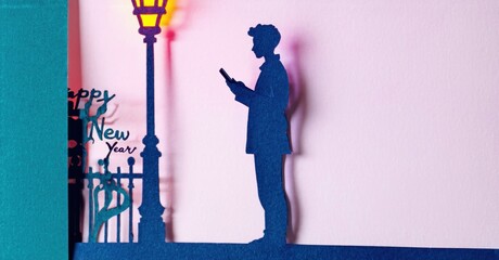 Obraz premium Papercraft scene depicts man near streetlamp. Text reads Happy New Years. Pink backdrop, blue details create festive mood.