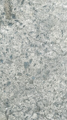 Texture of light gray stone, marble, or concrete surface with speckles.