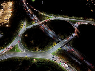 Aerial view over road traffic. Highway and overpass with cars and trucks, interchange, two-level road junction. Top view. Night shooting.