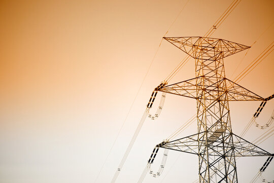 Dramatic power lines against warm gradient sky for infrastructure projects