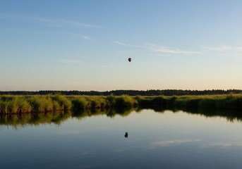 A perfectly smooth, glassy water surface reflecting the peaceful landscape above. Tranquil scene captured during the early morning hours ,background ,water ,element