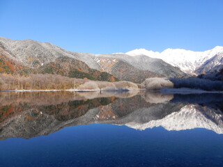 青空の青、冠雪の白、紅葉が織り成す晩秋の上高地と大正池に反射する穂高連峰