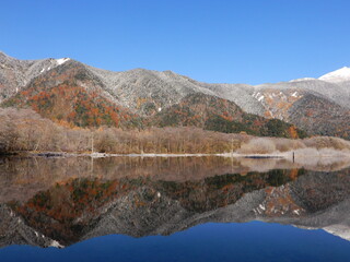 青空の青、冠雪の白、紅葉が織り成す晩秋の風景と大正池に反射する穂高連峰